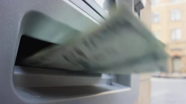 Cash withdrawal process at ATM showing banknotes emerging from the machine, highlighting the flow of money in a financial transaction outside a building