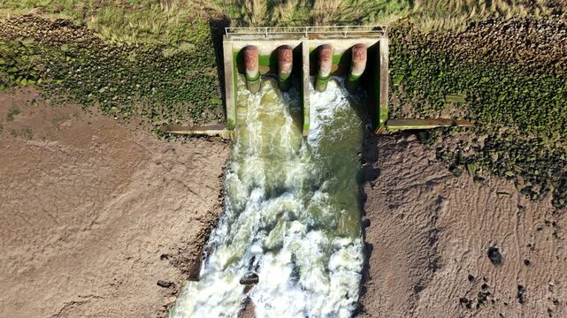 Drone view of water management facility releasing floodwater into the River Haven estuary.