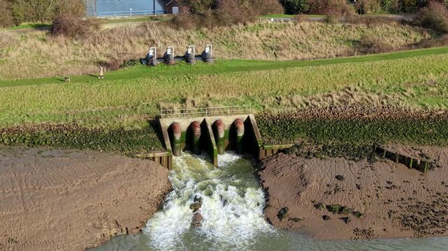 Drone view of hydraulic infrastructure discharging water into the River Haven for flood control.