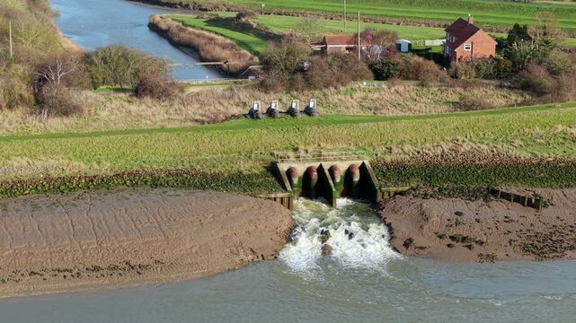 Aerial view of a pumping station outlet and water turbulence in the River Haven, England.