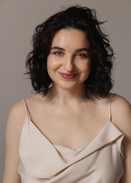 A studio portrait of a beautiful girl with curly hair and a lovely smile 