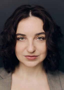 A studio portrait of a beautiful girl with curly hair and a lovely smile 