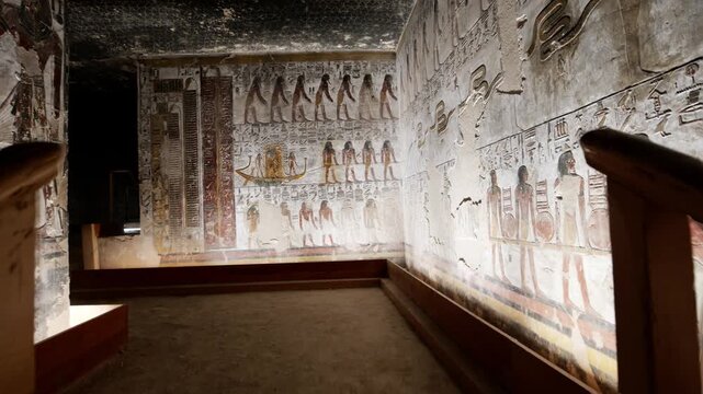 Close-up of ancient Egyptian relief carving inside KV17 tomb of Seti I, Valley of the Kings, Luxor, Egypt, showing a deity figure with black hair and deteriorating pigment.
