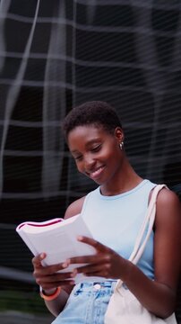 young woman engrossed in reading fiction book, cultivating her imagination and creativity. Her smile indicates enjoyment and engagement with story, highlighting joy of losing oneself in good book
