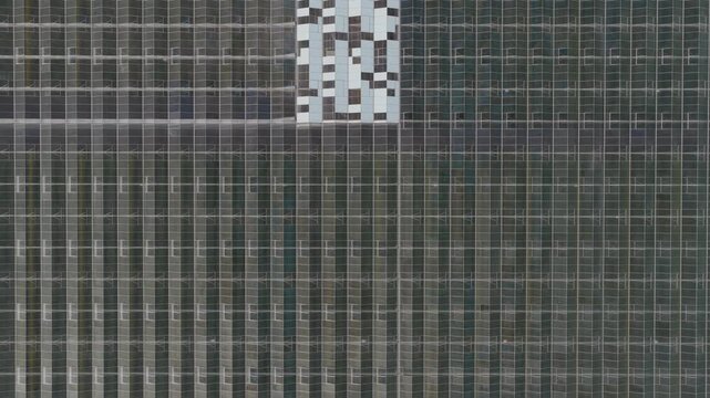Aerial view of the geometric patterns and glass panels of a large industrial greenhouse complex with white and grey sections Hrusky, South Moravian Region, Czechia.