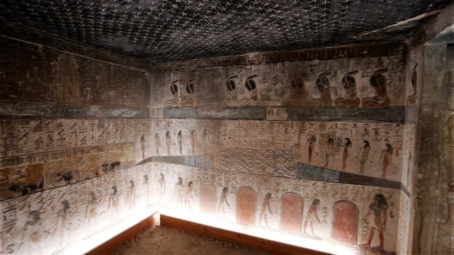 Close-up of ancient Egyptian relief carving inside KV17 tomb of Seti I, Valley of the Kings, Luxor, Egypt, showing a deity figure with black hair and deteriorating pigment.