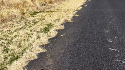 Aerial View of Asphalt Road Edge and Dry Grass in Rural Australia © blueringmedia