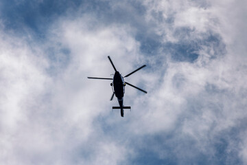 Helicopter in Flight with Thermal Imaging Camera Viewed from Below Against a Cloudy Sky, Aerial Surveillance Aircraft with Infrared Technology and Security Monitoring Concept © dreamcatcher