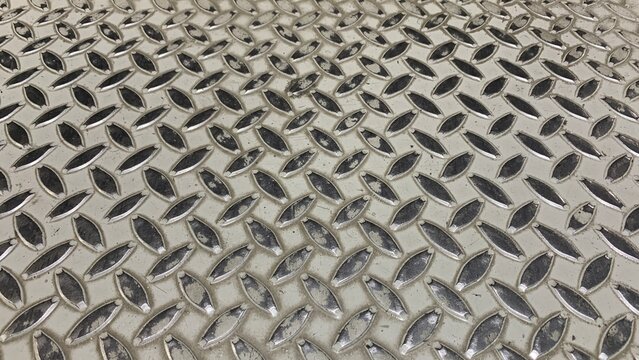 Close‑up view of a metal diamond plate surface with repeating raised tread patterns