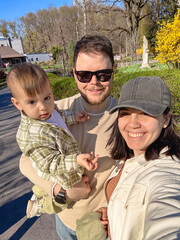 Fototapeta premium Happy young family selfie in sunny spring park Selfie