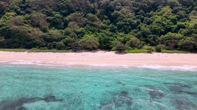 Aerial View of Gunung Payung Beach in Bali with Turquoise Ocean and Green Cliff