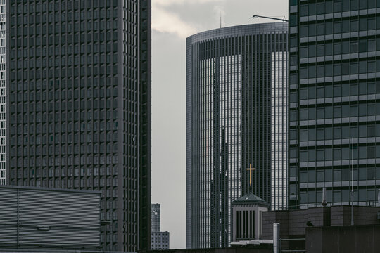 Office buildings and skyline towers stack above Frankfurt street levels, letting urban architecture and clouds frame the financial district
