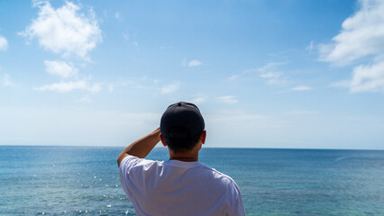 Back view of a man sitting on the seawall and looking at the summer sea 2 © Sona