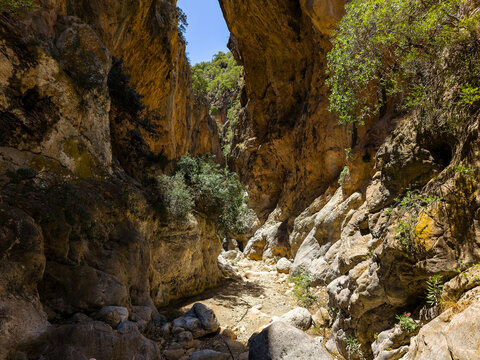 Hiking trail winding through steep rock walls of Sarakina Gorge in Crete, Greece
