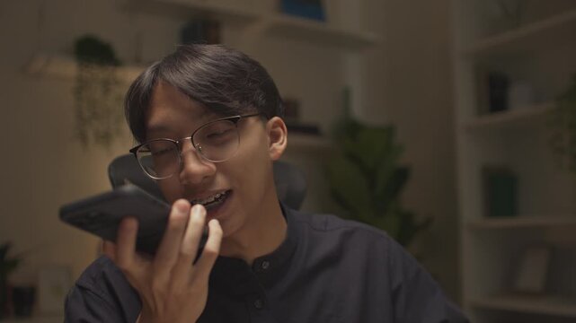 Modern man freelancer using AI voice assistant to make hands-free searches while working remotely, boosting productivity, embracing smart technology in a flexible work environment