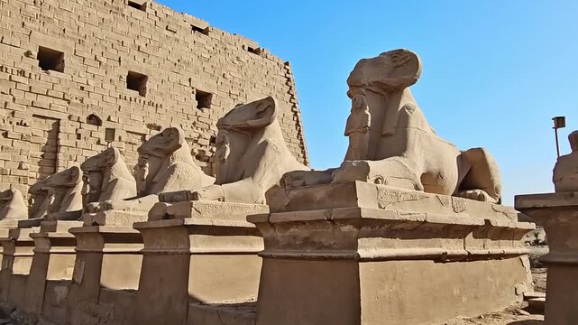 Karnak Temple in Luxor, Egypt. Ram-headed sphinx alley at Karnak Temple. Ancient stone statues of Amun god along sacred processional avenue.