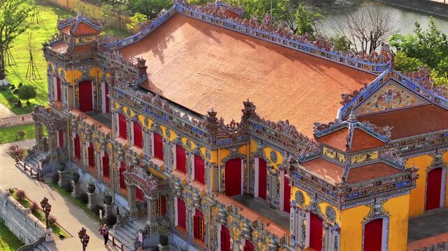 Kien Trung Palace in Hue Imperial City with a vibrant yellow facade, red shutters and roof details. Aerial Drone Shot