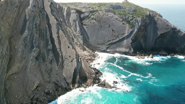 Aerial drone footage of Cabo Espichel, Portugal: dramatic Atlantic cliffs, rugged coastline and vast ocean landscape under natural light. Ideal for travel and nature projects.