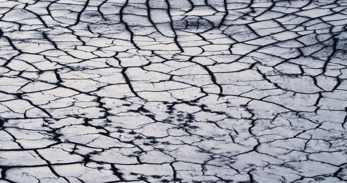 This mesmerizing video showcases the desolation of cracked earth under the relentless sun. The stark lines and patterns of dry land illustrate the harsh realities of climate and weather patterns.