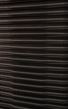 Stacked dark gray chairs creating a uniform pattern and texture.