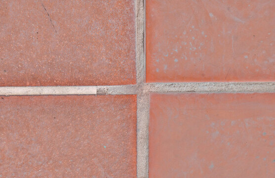 Close-up of terracotta tiles with textured surface and grout lines.