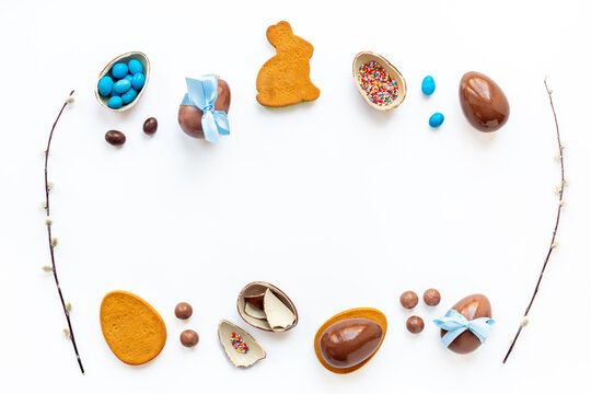 Top view of lots of chocolate Easter eggs with blue ribbon on a white background