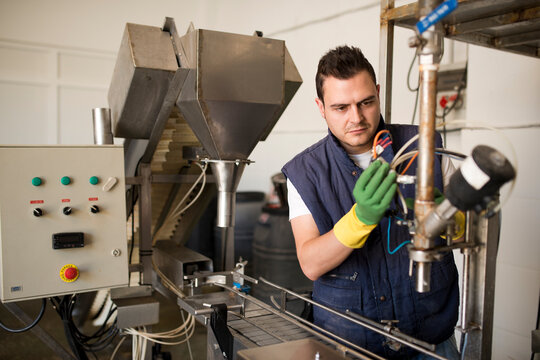 Worker programming and reparing factory machine