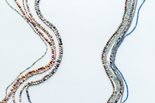 Beads and necklaces of many gemstones and pearls, top view. Jewelry concept.