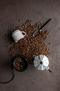 Geyser coffee maker with white cup and coffee beans on brown stone background, top view. Food concept photo