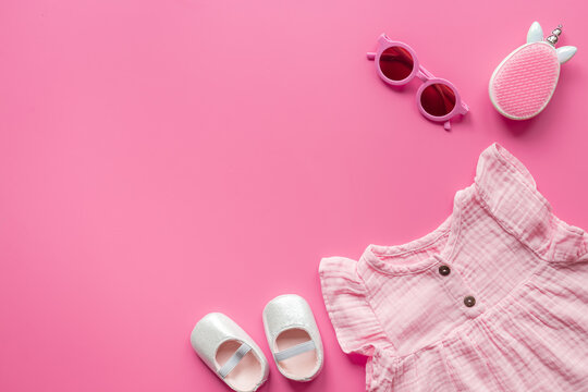 Baby girl pink cotton muslin dress with shoes and accessories, top view. Kids stylish summer clothes