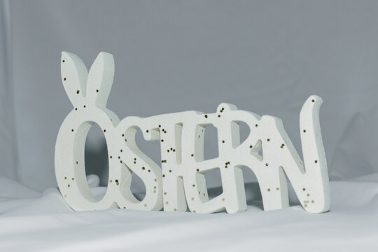 Easter decoration with wooden &ldquo;OSTERN&rdquo; lettering and bunny silhouette on soft background