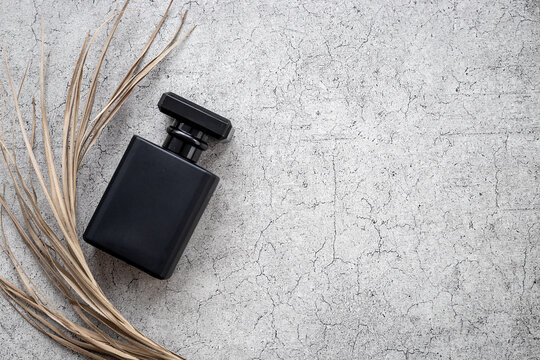Stylish men perfume in a black bottle top view. Male fragrance and cosmetic concept