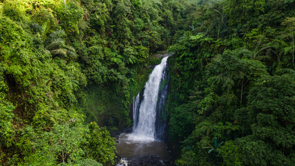 Aerial view of Beautiful Gomblang Waterfall in the middle of forest, Java, Indonesia. Dense waterfall with lush vegetation  © katakaneh
