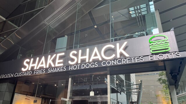 Shake Shack restaurant exterior with illuminated company logo and menu items sign at the Tokyo International Forum building in Chiyoda - Tokyo, Japan, October 16, 2025