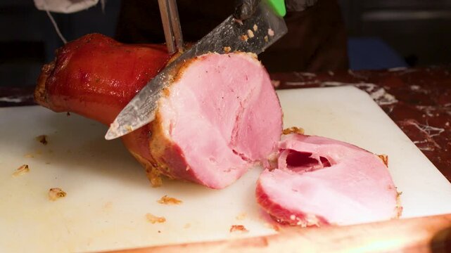 Chef in Black Gloves Slicing Roasted Ham on Cutting Board
