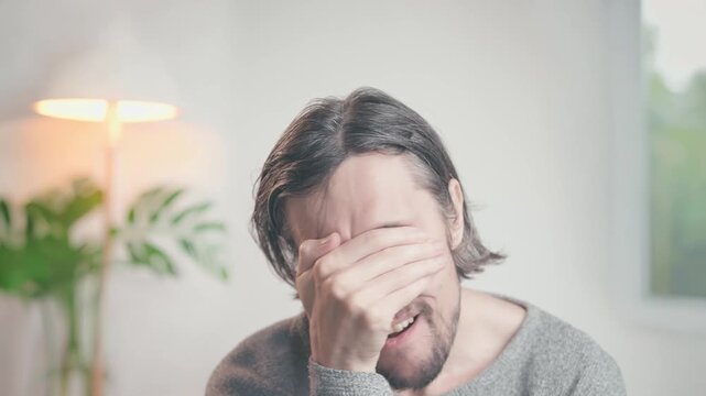 Facepalm: A man in a warmly lit room making slow, deliberate movements showing curiosity, worry, frustration, surprise, and disbelief in a reflective, intimate atmosphere