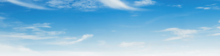 Obraz premium Soft clouds drift gently across a vast, serene blue sky