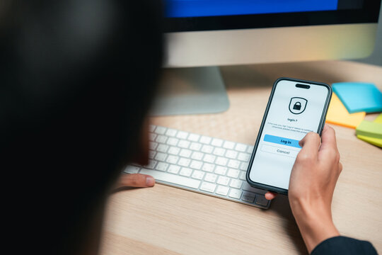 Man freelancer working from home, using two-factor authentication on his smartphone to securely log in and access digital tools, embracing cybersecurity, smart work habits, and modern remote workflows