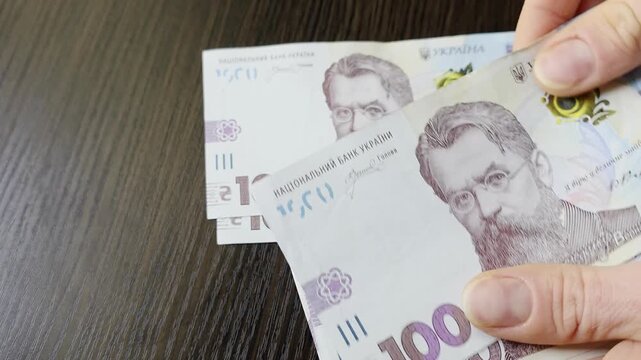 Close up of hands holding paper bills of one thousand Ukrainian hryvnia