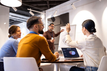 Business professionals discussing market data during an internal presentation, team member asking question © littlewolf1989