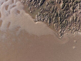 Coastal rocky beach terrain with exposed boulders, wet sand textures and open sea backdrop © Wirral Views