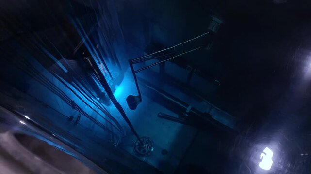 Blue glow water of nuclear reactor core powered, caused by Cherenkov radiation, fuel plates industrial uran.
