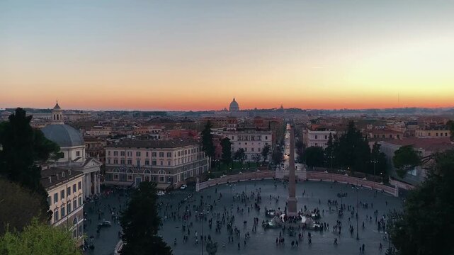 People walking and gathering across piazza del popolo Rome Italy at sunset from elevated.