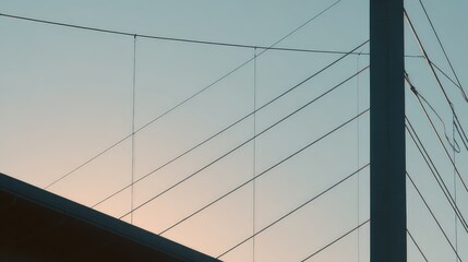 Obraz premium Tension cable bridge with concrete pylon silhouetted against a soft dusk sky, clean geometric lines and minimalist contrast evoking engineering, connection and urban progress