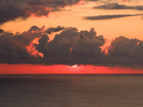 Aerial view of the sunset over the Indian Ocean near Mauritius Island with dramatic red clouds and calm water Moka District, Mauritius.