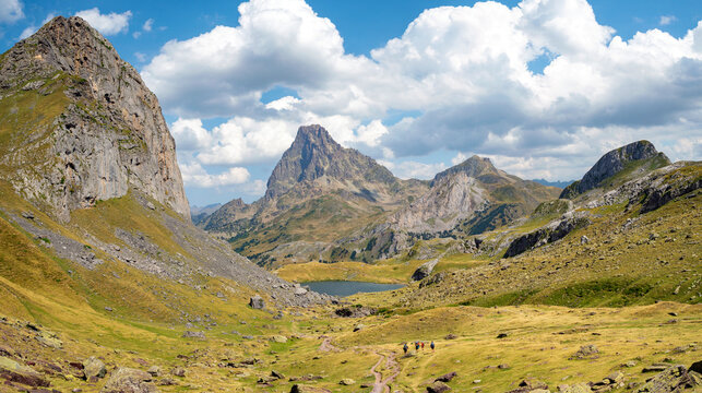 Senderistas en la ruta de los 7 lagos, con vistas del Pic Casterau y el Pic Midi d&acute;Ossau, en el departamento Pirineos Atl&aacute;nticos, Francia