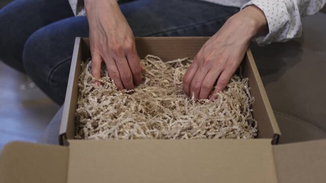 Cardboard box. Gift. Shredded paper. Slow motion video. . High quality 4k footage