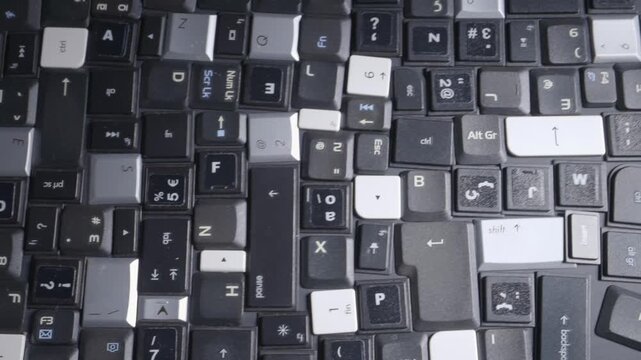 Close-up of a collection of keyboard keys from different old laptops on a table