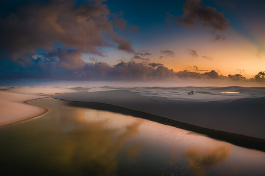 Aerial view of the vast white sand dunes and freshwater lagoons of Parque Nacional dos Lencois Maranhenses during a golden sunset Lencois Maranhenses, MA, Brazil.