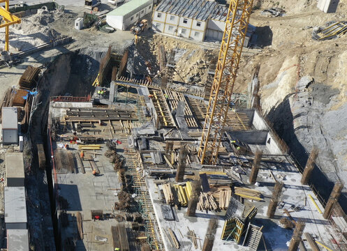 Aerial view of a large construction site with foundation rebar, workers, and a yellow crane in Avcilar, Istanbul, Turkiye.
